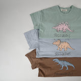 Flat lay of three kids dinosaur shirts in mint, blue, and brown