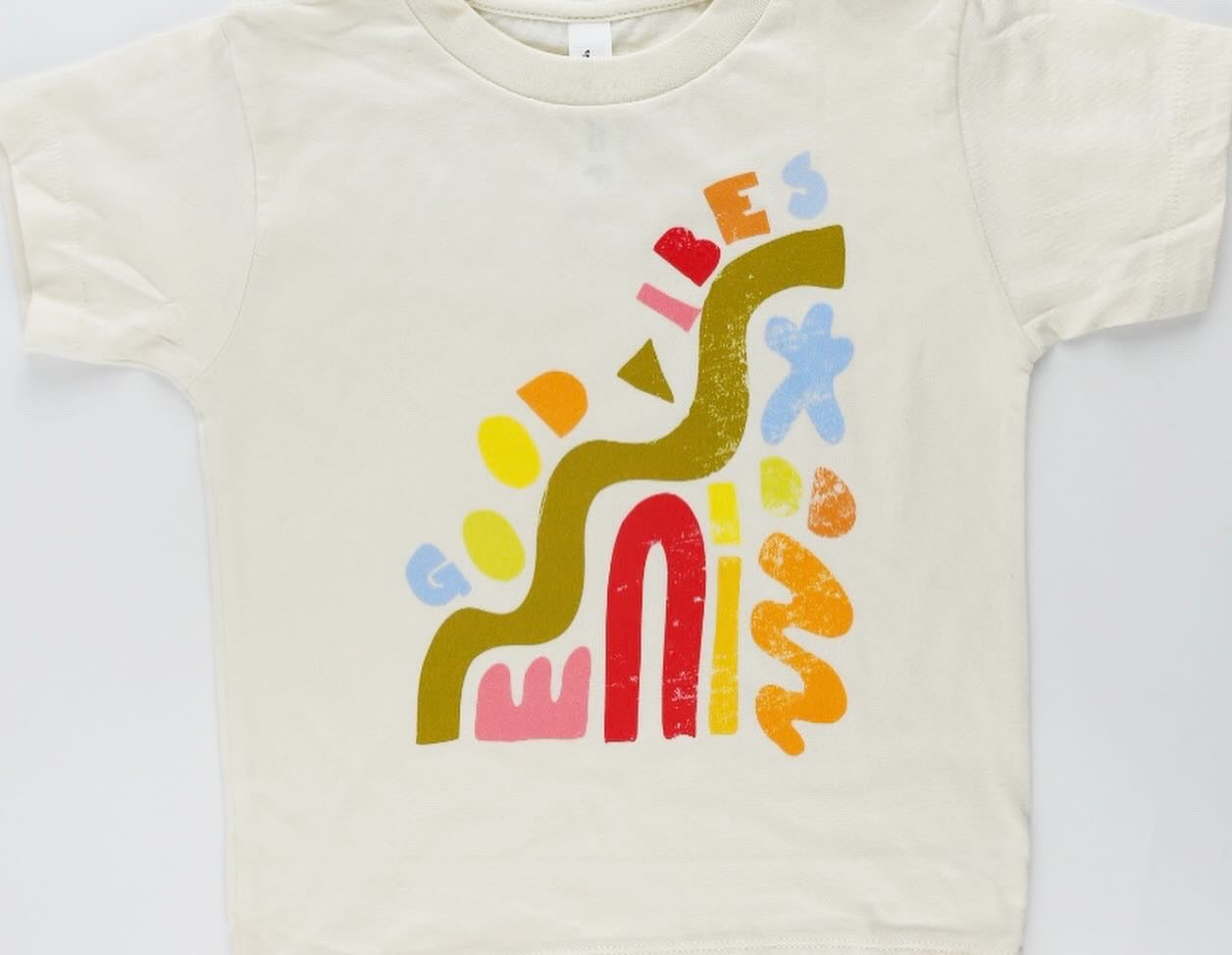 Good Vibes kids graphic tee with colorful abstract shapes